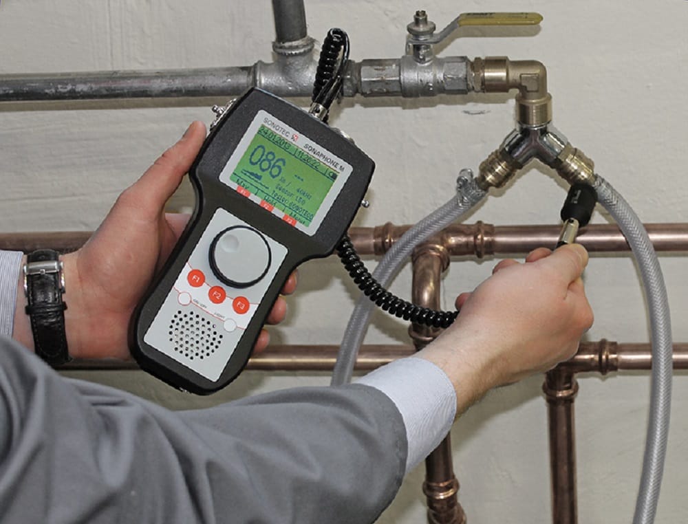 Plumber testing pipes with electronic leak detection equipment in Seminole