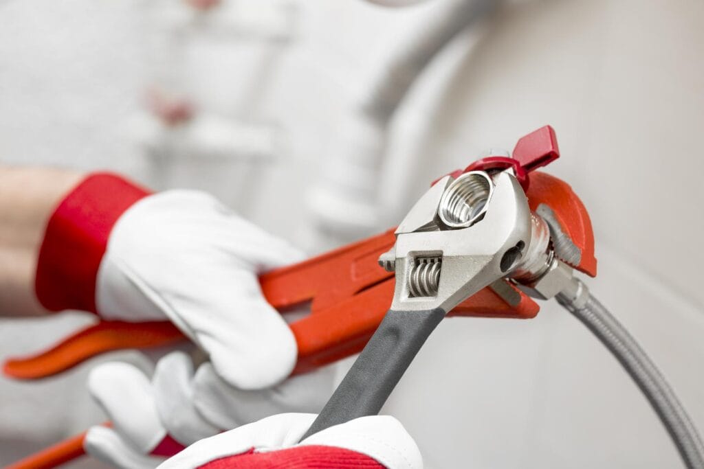 Plumber holding pipe wrenches for an emergency repair in Seminole