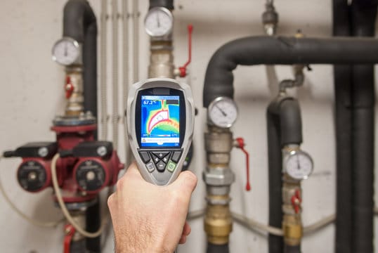 Plumber using a thermal imaging camera to inspect pipes in Seminole
